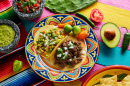 Mexican Platillo Tacos of Barbacoa and Vegetarian With Sauces and Colorful Table