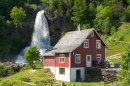 Traditionelles Haus und Wasserfall in Norwegen