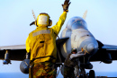 Matrose dirigiert ein F-18 Hornet