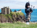 Schottischer Dudelsackspieler nahe Schloss Dunnottar