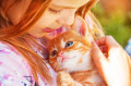 Kleines Mädchen mit einem roten Kätzchen