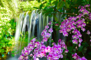 Wasserfall mit Blumen im Garten