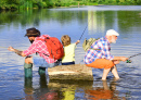 Drei Männer, die im Sommer an einem Fluss fischen
