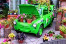 Blumen mit einem grünen Retro-Auto
