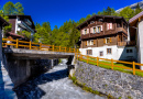 Fluss und Chalets in einem Schweizer Dorf in den Alpen