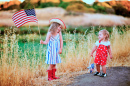 Zwei kleine Mädchen schwenken die amerikanische Flagge