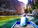 Ein alter Mann, der ein Boot steuert, Wadi Shab, Oman