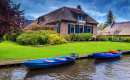 Haus am Wasser und festgemachte Motorboote, Giethoorn