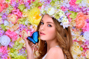 Junge Frau im Blumenkranz mit einem Schmetterling
