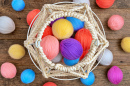 Weißer gestrickter Korb und bunte Wollknäuel