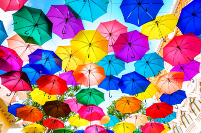 Mehrfarbige Regenschirme, die über der Straße schweben