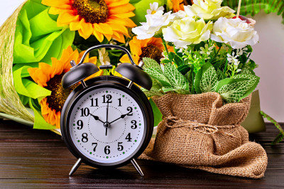 Stillleben mit einem Vintage-Wecker und Blumen